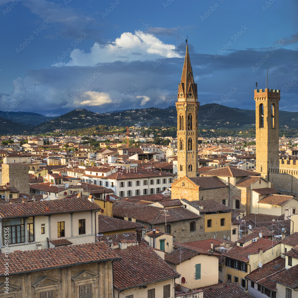 Old tower and belfry with sun lights and clouds in Florence in Italy