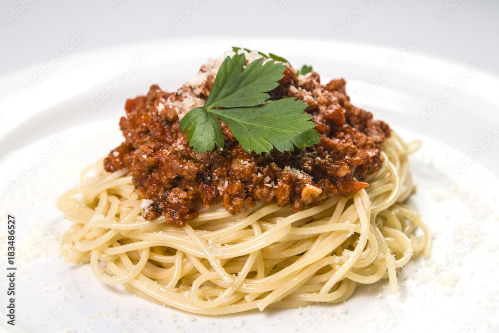 Italian spaghetti pasta with beef and tomato sauce bolognese on white plate Italian spaghetti pasta with beef and tomato sauce bolognese on white plate