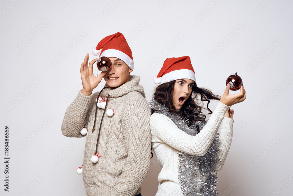 man and woman fooling around with New Year's toys, couple, holiday, christmas, new year, emotions, winter, light background man and woman fooling around with New Year's toys, couple, holiday, christmas, new year, emotions, winter, light background