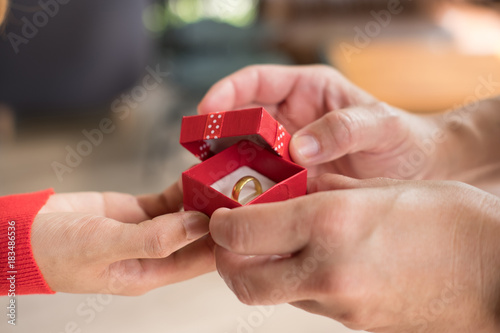 man giving gift box with engagement ring to woman. boyfriend making marriage proposal to girlfriend. Romance, birthday, valentine, love, wedding concept