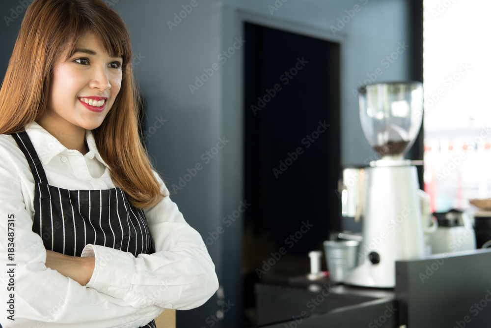 small business owner standing at counter in coffee shop. female barista wearing apron smiling at bar in cafe. food service, restaurant concept.