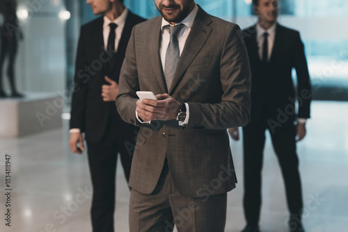 cropped image of businessman looking at smartphone photo