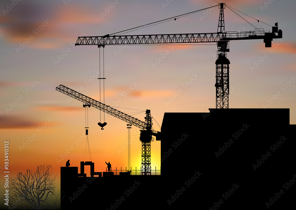 two hoisting cranes above building at sunset two hoisting cranes above building at sunset