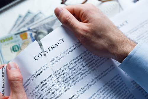Disappointed or deceived businessman tears up a contract photo