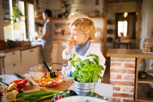 Young father with a toddler boy cooking.