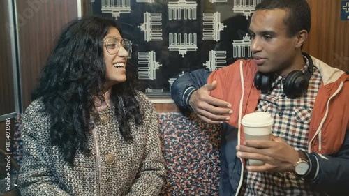 Middle Eastern woman and an African man traveling on a train in Berlin underground and talking photo