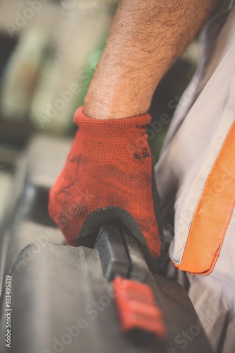 Senior man in workshop. Man holding carries tool bag. Close up.