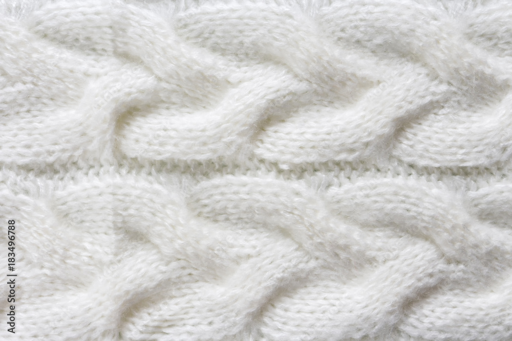 Texture of a knitted product close-up with a pattern of braids of white color and large loops top view of a flat Texture of a knitted product close-up with a pattern of braids of white color and large loops top view of a flat