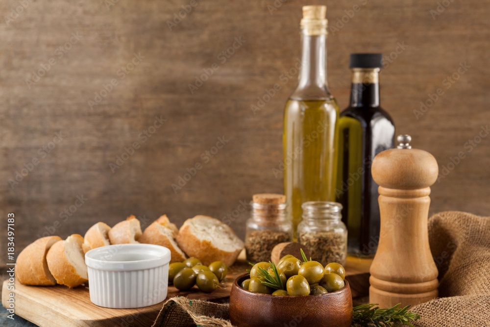 Olives with pepper shaker and oil bottles by bread Olives with pepper shaker and oil bottles by bread