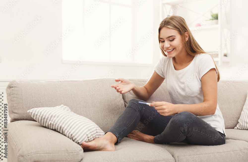 Happy girl reading the results of her pregnancy test