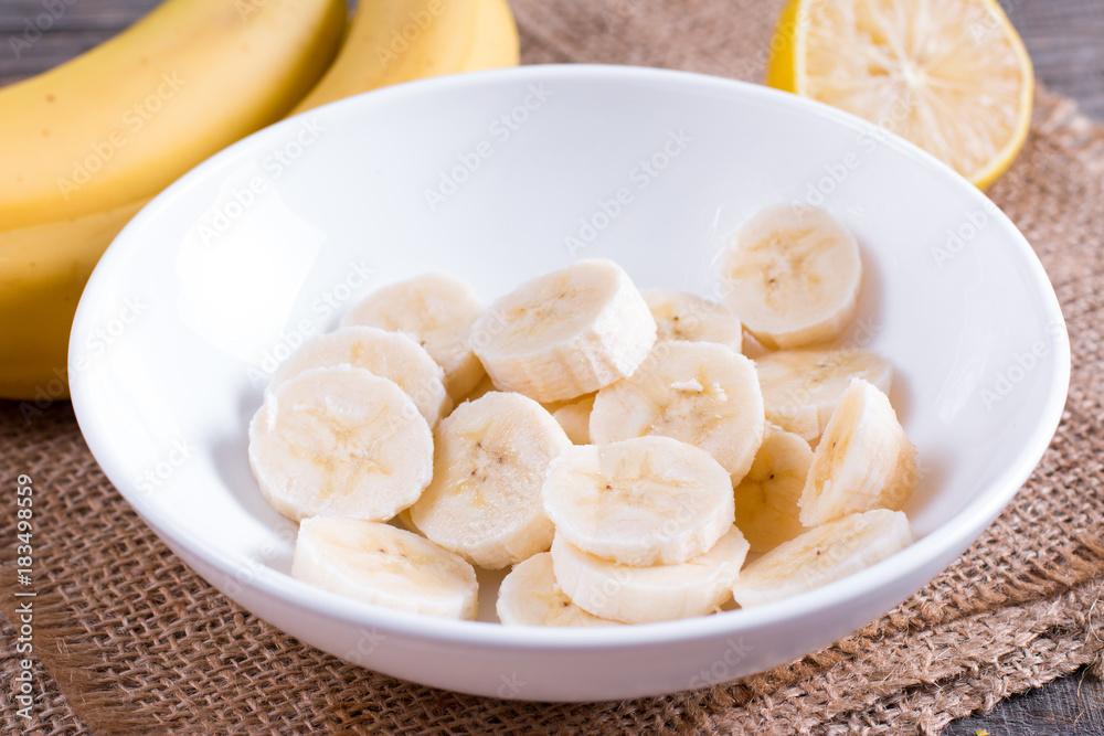 Slices of banana in a white bowl on the table