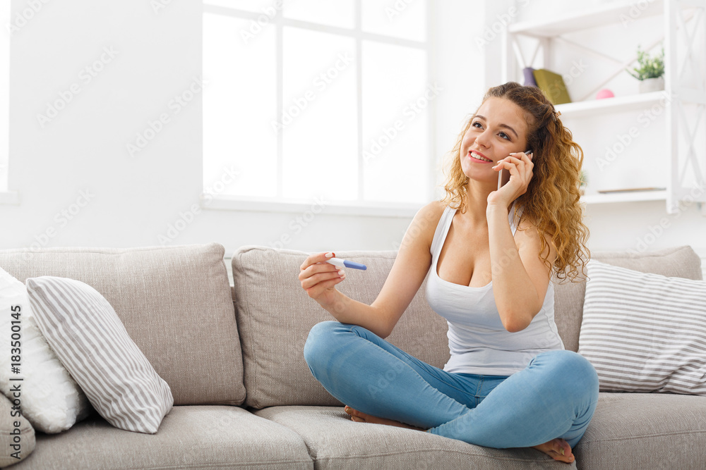 Good news. Girl with pregnancy test talking on mobile Good news. Girl with pregnancy test talking on mobile
