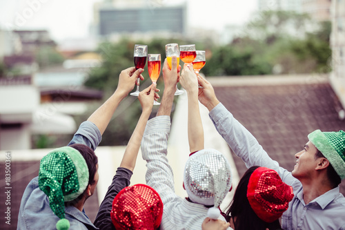 Cheers to best friends! Top view of cheerful young people cheering with champagne flutes and looking happy while having party on the kitchen ,celebrating Christmas or New Year at home  photo