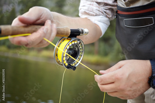 Fly fisherman using a spinning reel
