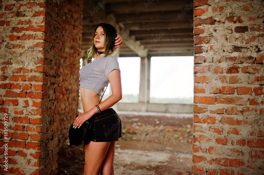 Girl wear on shorts at abadoned factoty with brick walls. Girl wear on shorts at abadoned factoty with brick walls.