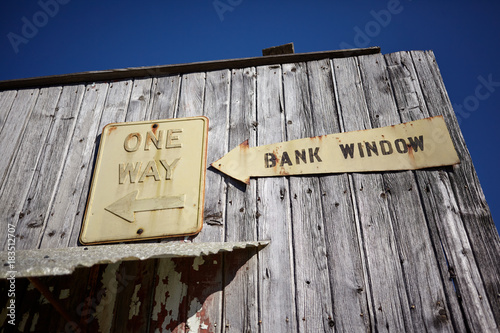 Old weathered timber clad building with bank sign © Colby