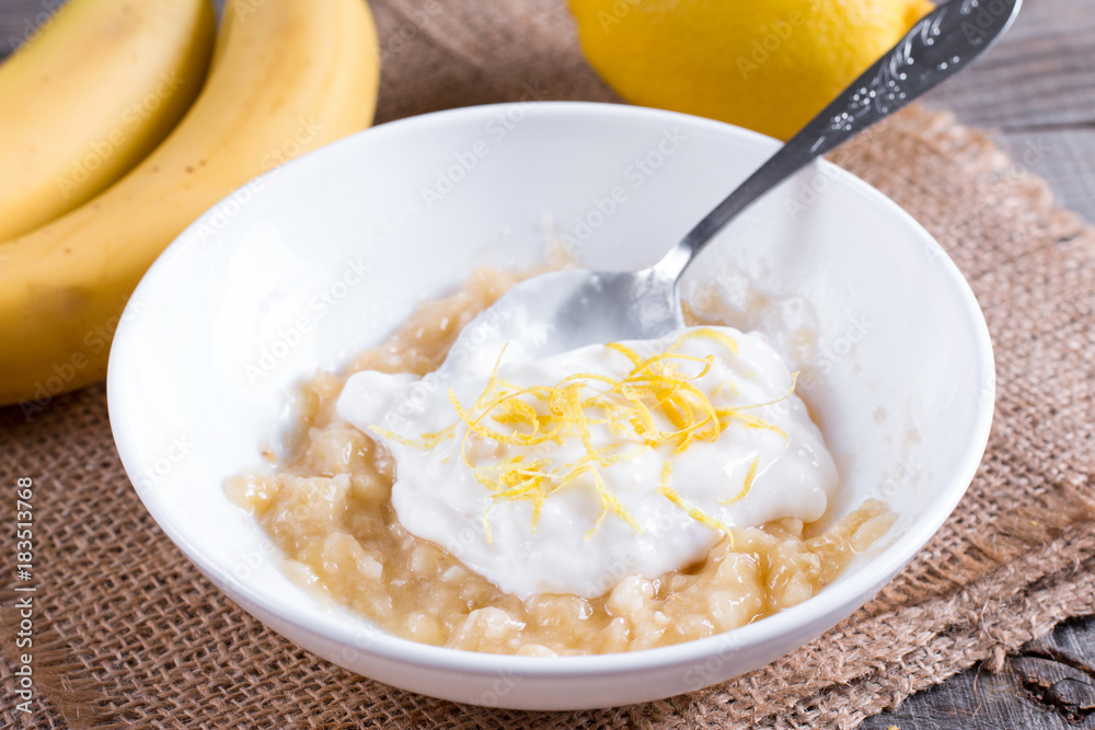 Banana puree with yogurt and lemon zest in a white bowl Banana puree with yogurt and lemon zest in a white bowl