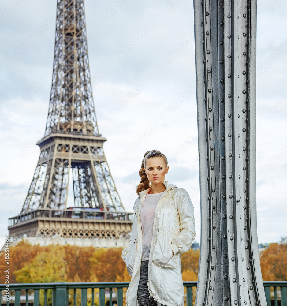 young fitness woman standing against Eiffel tower in Paris