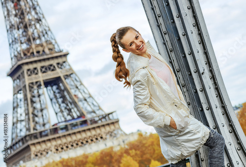 Photography happy young fitness woman against Eiffel tower in Paris
