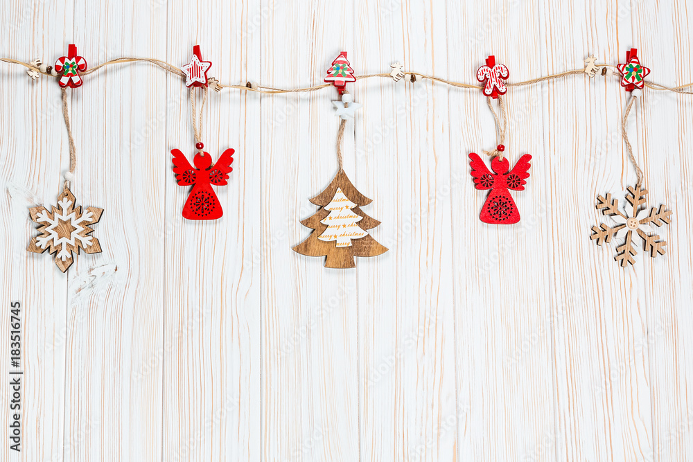 Christmas wooden toys are hung on a rope on a white wooden background. Beautiful festive greeting card with free space Christmas wooden toys are hung on a rope on a white wooden background. Beautiful festive greeting card with free space