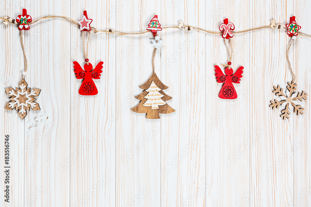 Christmas wooden toys are hung on a rope on a white wooden background. Beautiful festive greeting card with free space Christmas wooden toys are hung on a rope on a white wooden background. Beautiful festive greeting card with free space