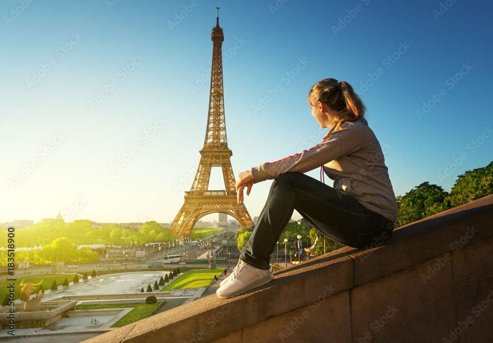 girl looking at the Eiffel tower in sunrise time, Paris - obrazy, fototapety, plakaty 