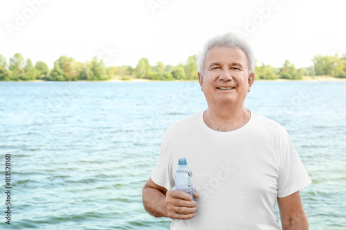 Mature man with bottle of w...