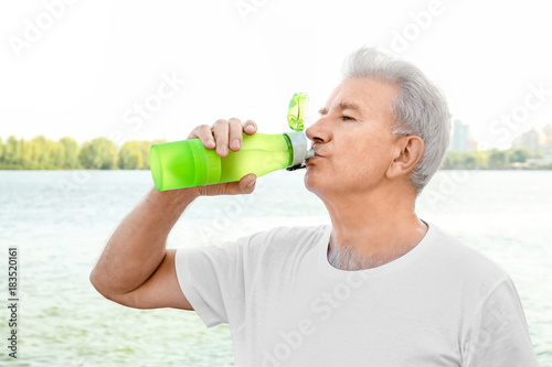 Mature man drinking water o...