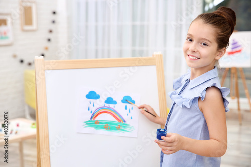 Little girl painting rainbo...