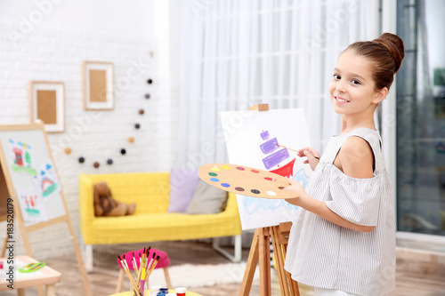Little girl painting boat at home