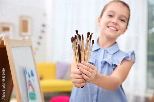 Little girl holding many pa...