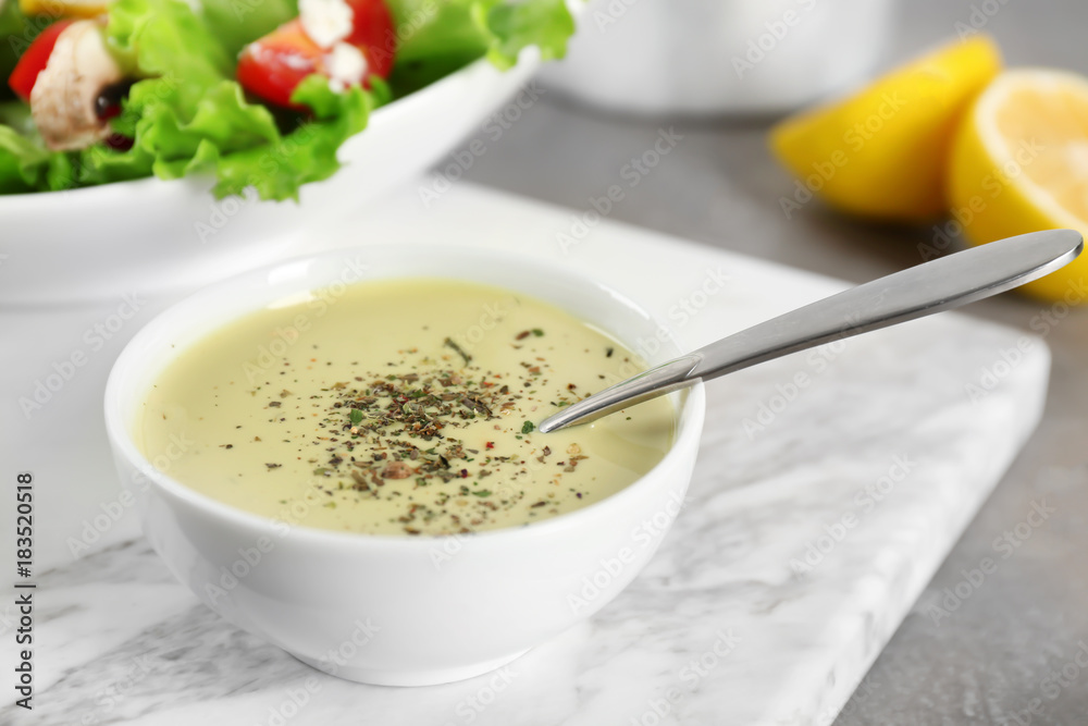 Ceramic bowl with ranch salad dressing on table Ceramic bowl with ranch salad dressing on table