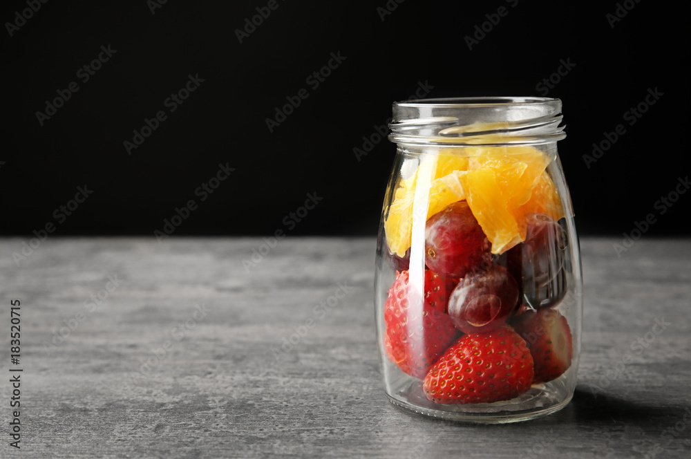 Delicious fruit salad in jar on table Delicious fruit salad in jar on table