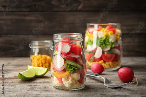 Delicious vegetable salad in jar on table