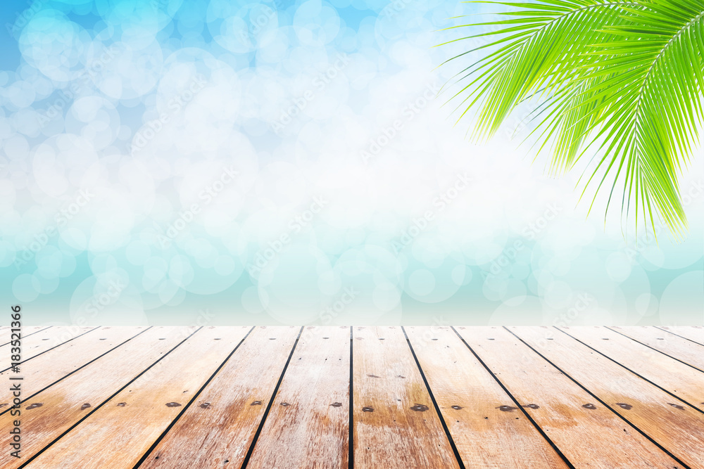 Empty wooden table and palm leaves with party on beach holidays blurred background in summer time. Empty wooden table and palm leaves with party on beach holidays blurred background in summer time.