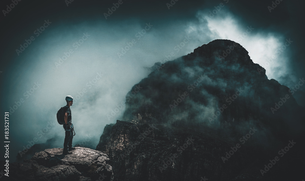 Mountain climber and dark, ominous, stormy view
