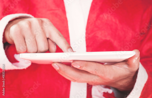 Santa Claus using on a digital tablet.