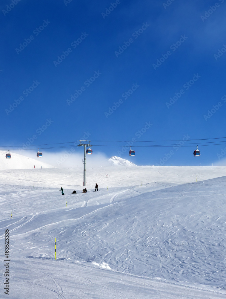 Gondola lift and snowy ski slope in fog