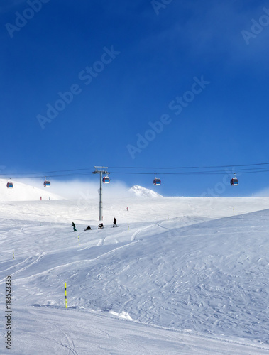Gondola lift and snowy ski slope in fog
