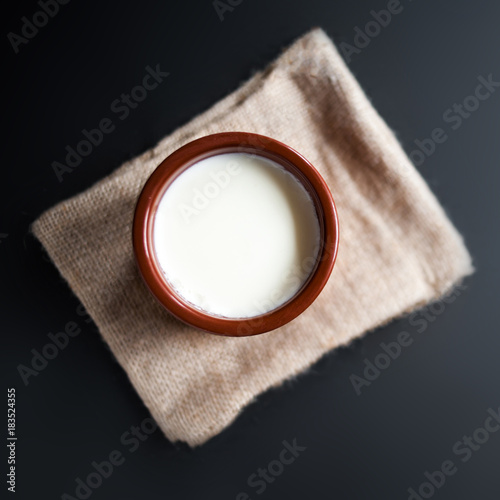 Sour  cream or natural  Cottage cheese curd  in traditional ceramic bowl on dark  background. Traditional Cuajada yogurt cream photo