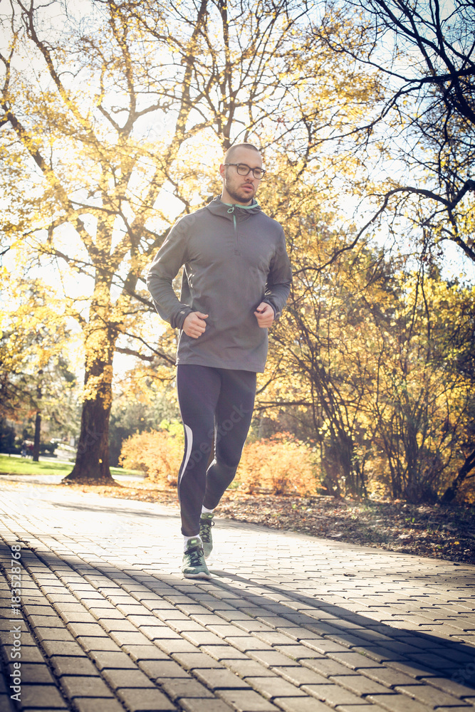 Fototapeta premium Young man run trough public park.