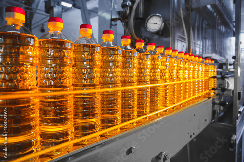 Oil in bottles. Industrial production of sunflower oil. Conveyor line for bottling and packing. Sunflower oil plant.