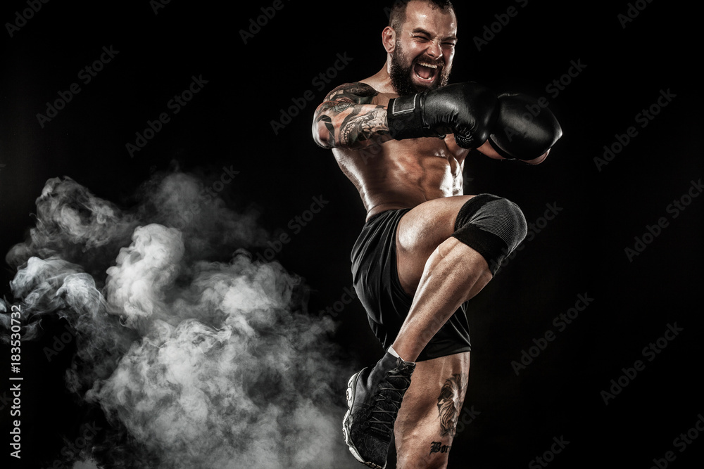 Sportsman muay thai boxer fighting on black background with smoke. Copy Space. Sport concept.