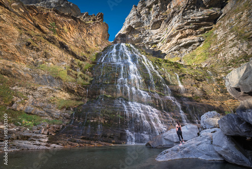 Hikker womann looking at Horsetail waterfall in Ordesa national park, Pyrenees, Spain. photo