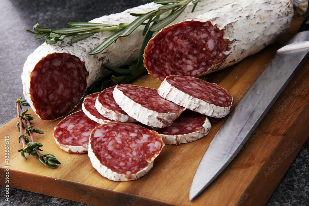Marble cutting board with sliced salami on it Marble cutting board with sliced salami on it