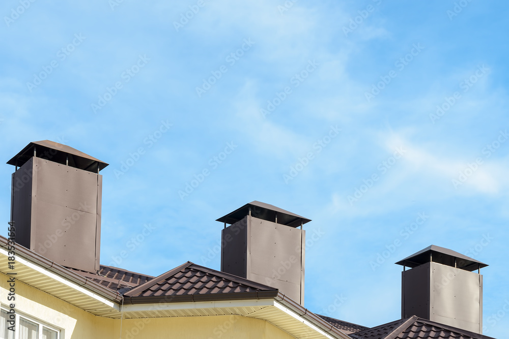 the roof of the house with pipes on background of blue sky