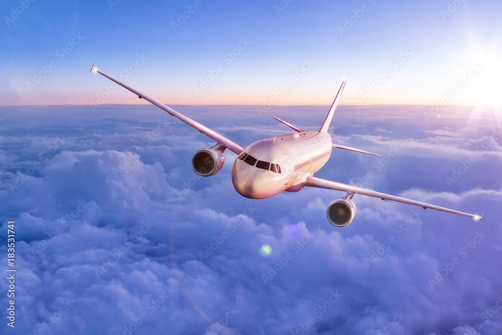 Obraz premium Samolot komercyjny lecący nad chmurami