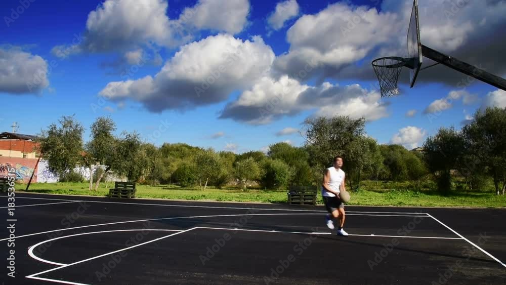 Basketball player working out in playground on a cloudy day Basketball player working out in playground on a cloudy day