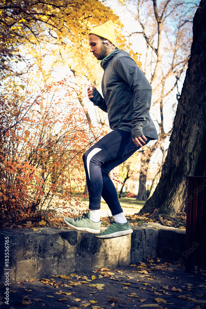Fototapeta premium Jumping squats in nature. Man exercise.