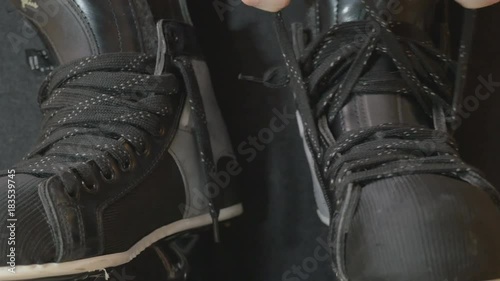 hockey player tightening laces on his skates